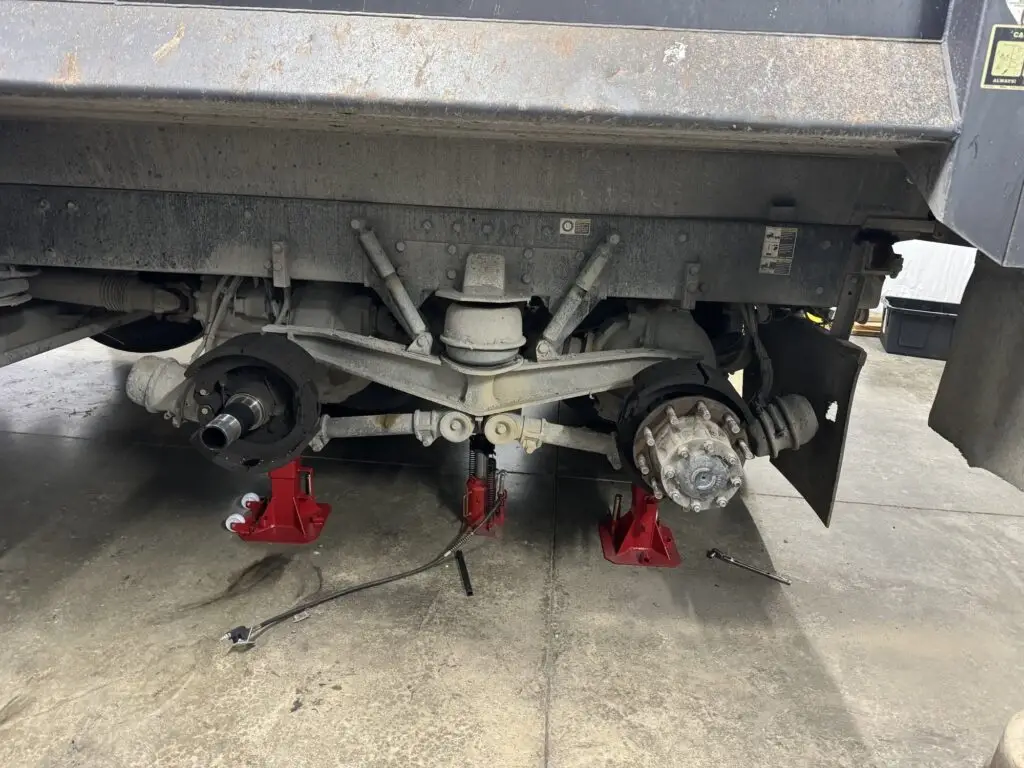 Semi truck on jack stands awaiting a suspension repair and tire replacement at the Hudson Roadside Repair shop in Fort Wayne Indiana.